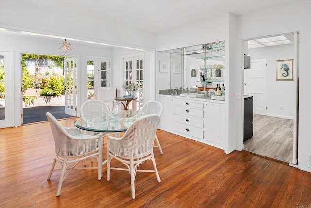 dining room featuring wet bar and light wood finished floors
