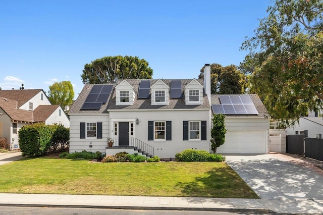 new england style home featuring solar panels, a chimney, driveway, and a front yard