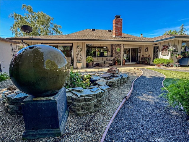 7019 Fairfield Dr, Santa Rosa, CA 95409 - back of property with a chimney, a patio, board and batten siding, a shingled roof, and an outdoor fire pit