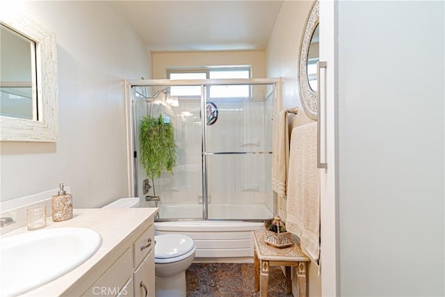 full bathroom with vanity, bath / shower combo with glass door, and toilet