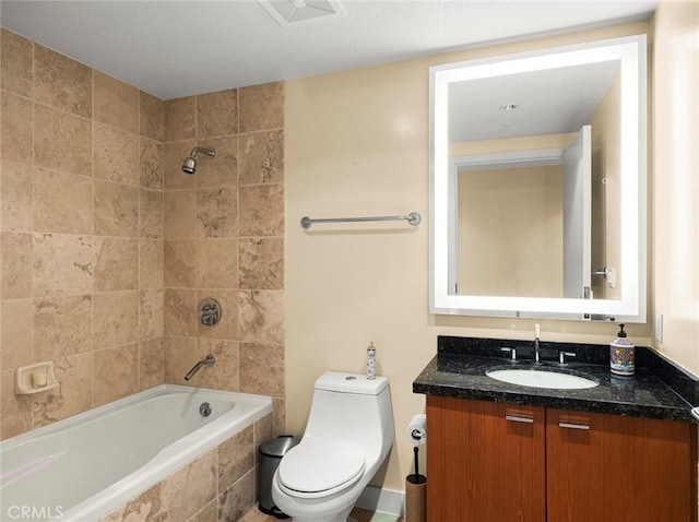 full bathroom featuring toilet, tiled shower / bath, and vanity
