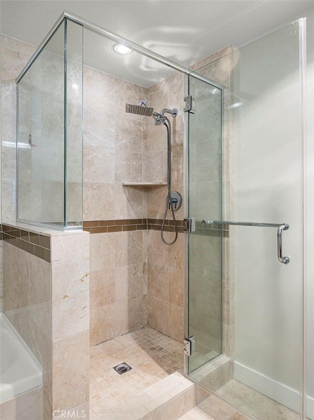 full bathroom featuring tile patterned floors, a shower stall, and a garden tub