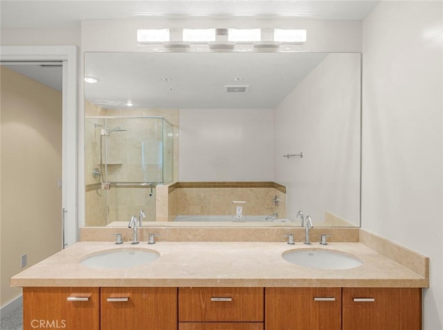 full bath featuring double vanity, a shower stall, a sink, and a bath
