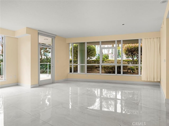 spare room with baseboards and marble finish floor