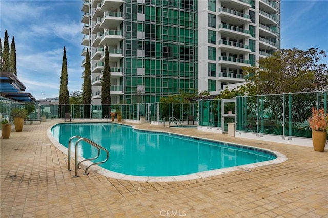 pool with a patio and fence