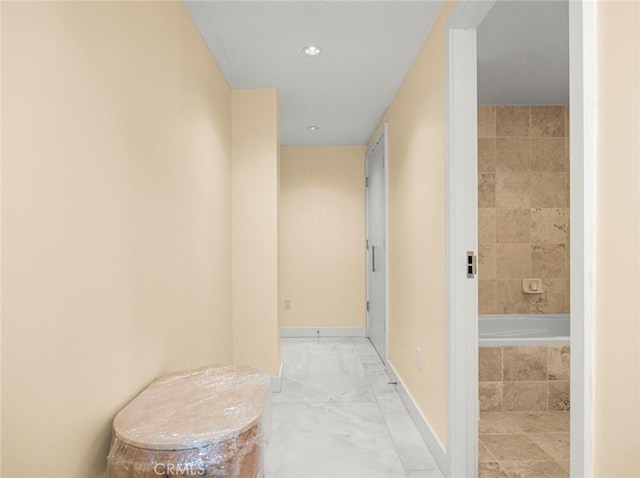 hallway featuring baseboards and recessed lighting