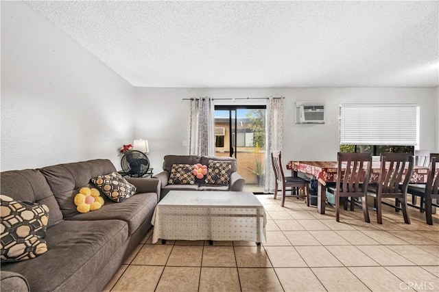 living room featuring a textured ceiling, a wall mounted AC, and light tile patterned floors