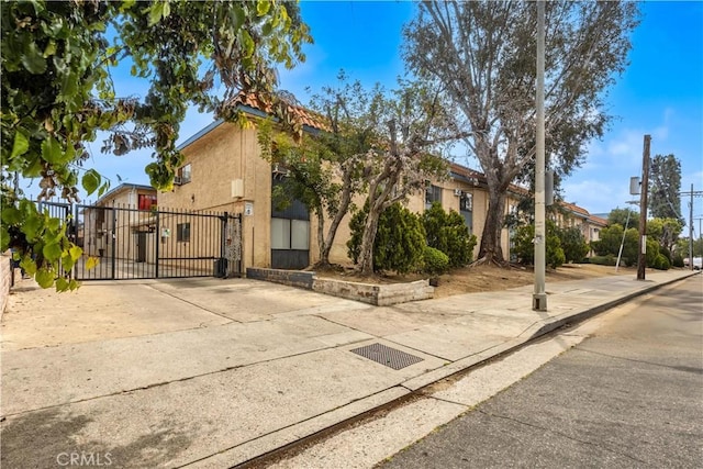 view of front of property with fence, a gate, and stucco siding