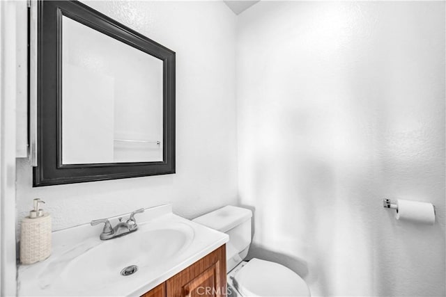 bathroom featuring toilet and vanity