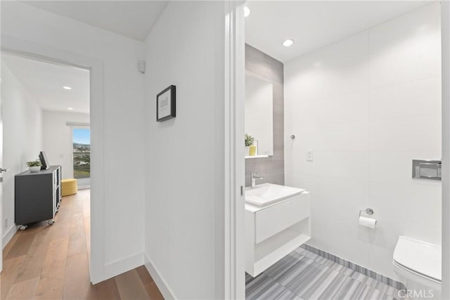 303 Calle Paisano, San Clemente, CA 92673 - bathroom with tile walls, toilet, baseboards, vanity, and wood finished floors