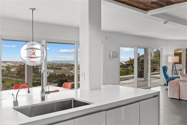303 Calle Paisano, San Clemente, CA 92673 - kitchen with a wealth of natural light, white cabinetry, light countertops, and a sink