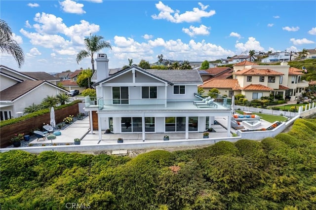 303 Calle Paisano, San Clemente, CA 92673 - back of house featuring a balcony, a chimney, a patio area, a residential view, and a fenced backyard