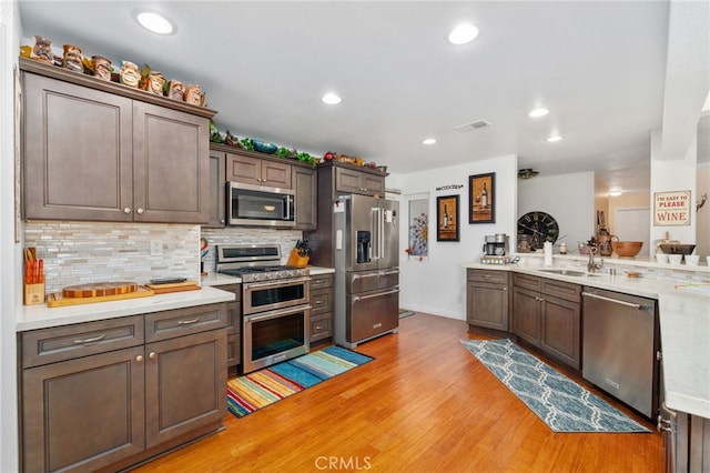 1316 Via Ln, Ranchita, San Marcos, CA 92069 - kitchen with a sink, light countertops, light wood-style flooring, stainless steel appliances, and decorative backsplash