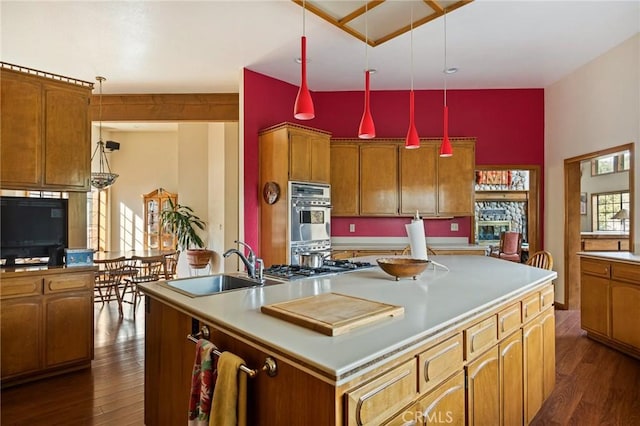 32424 Snowshoe Ln, Running Springs, CA 92382 - kitchen featuring brown cabinetry, a sink, dark wood-style flooring, and stainless steel double oven