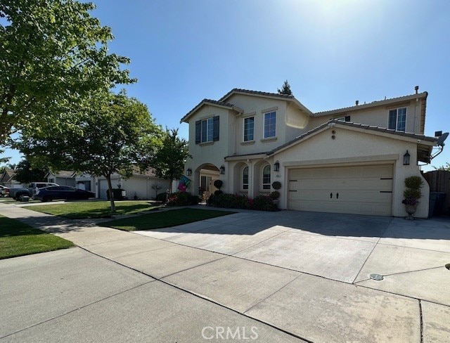 traditional-style house with an attached garage, driveway, a front lawn, and stucco siding