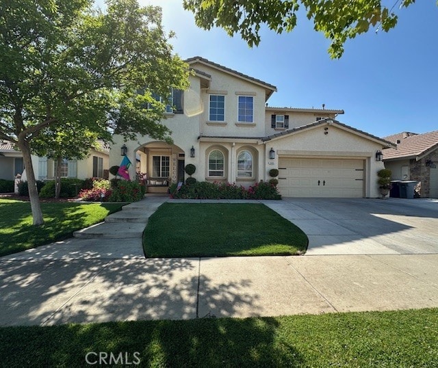 view of front of home with a garage, driveway, a front yard, and stucco siding