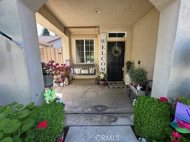 property entrance with stucco siding and fence