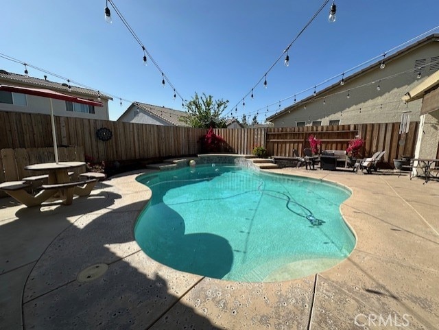 view of pool featuring a patio, a fenced backyard, and a fenced in pool
