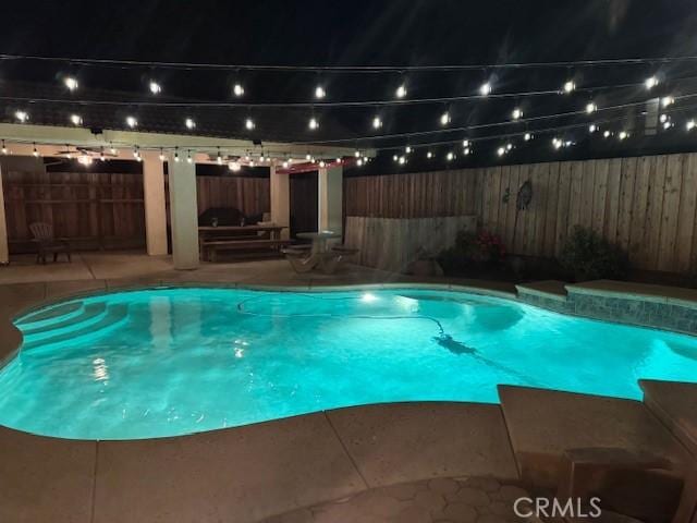 view of swimming pool with a patio and a fenced backyard