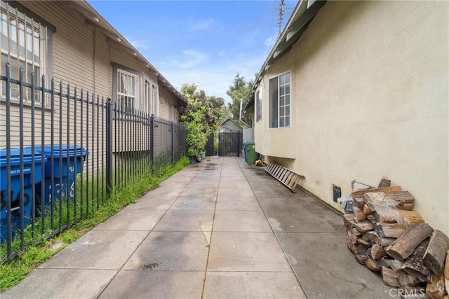 view of side of property with fence, a patio, and stucco siding