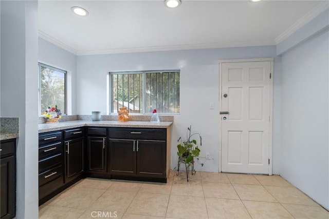 kitchen featuring light stone countertops, light tile patterned flooring, ornamental molding, and recessed lighting