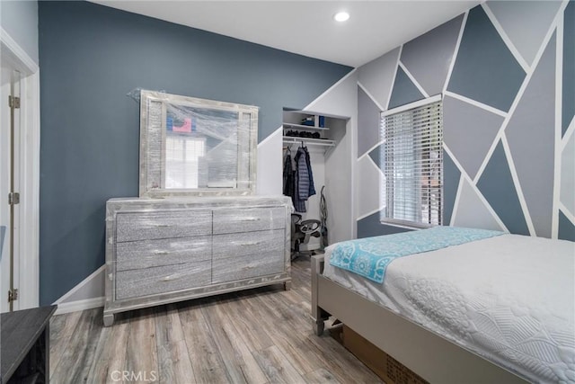 bedroom with baseboards, a closet, recessed lighting, and wood finished floors