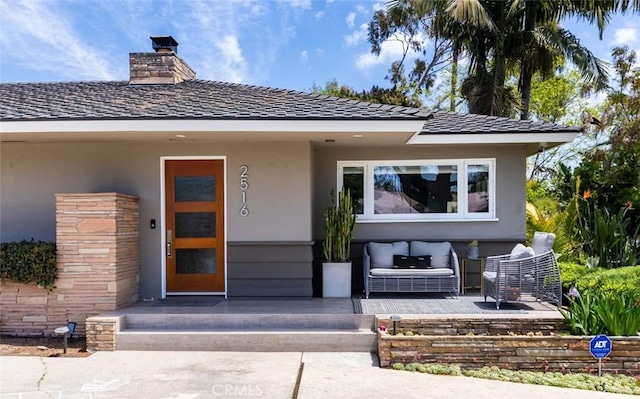 doorway to property with a chimney and stucco siding