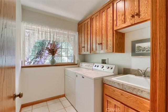 laundry room with washing machine and clothes dryer, cabinet space, a sink, baseboards, and light tile patterned flooring