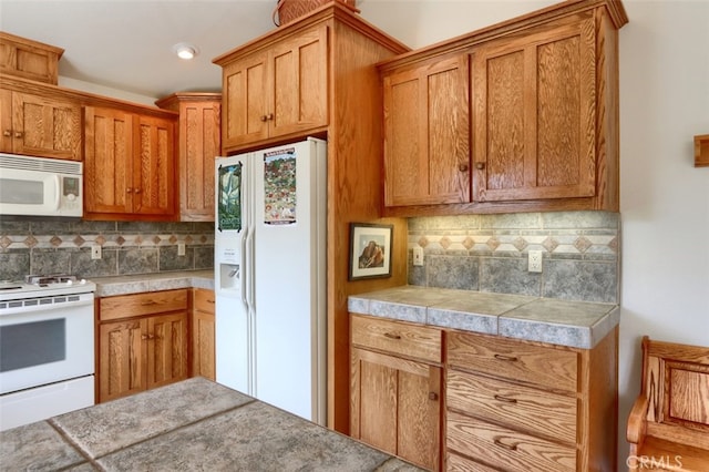 kitchen featuring white appliances, brown cabinetry, decorative backsplash, and light countertops
