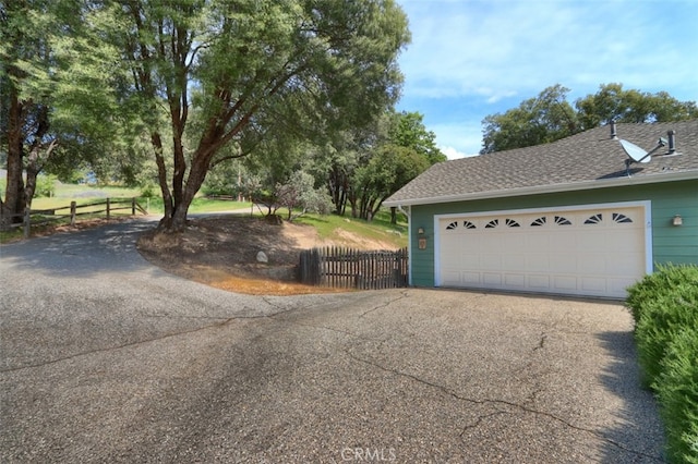 garage featuring fence and driveway