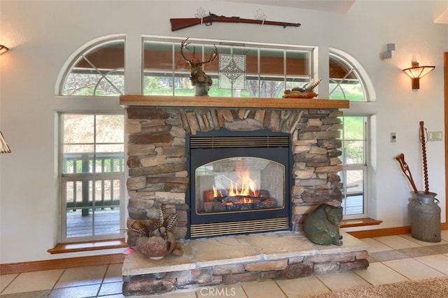 interior details with baseboards and a stone fireplace