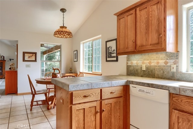 kitchen with white dishwasher, a wealth of natural light, brown cabinetry, and lofted ceiling
