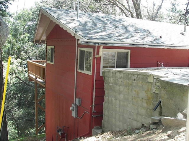view of side of property featuring roof with shingles
