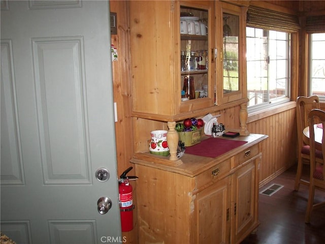 interior details featuring wood walls, visible vents, wood finished floors, and a fire extinguisher