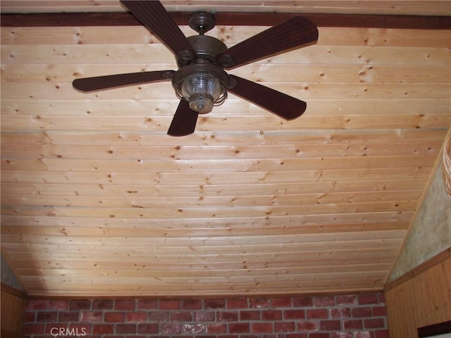 room details featuring wooden walls and a ceiling fan