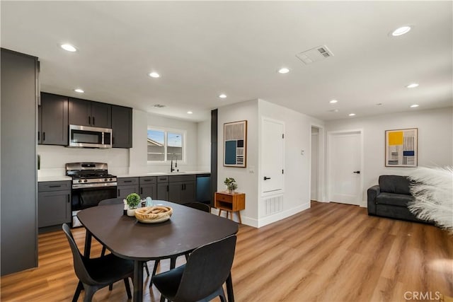 dining area with recessed lighting, baseboards, light wood-type flooring, and visible vents