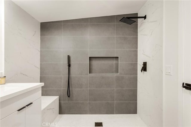 bathroom with vanity and a tile shower