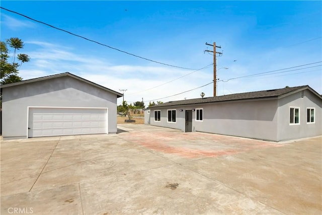 view of front of property featuring stucco siding and a detached garage