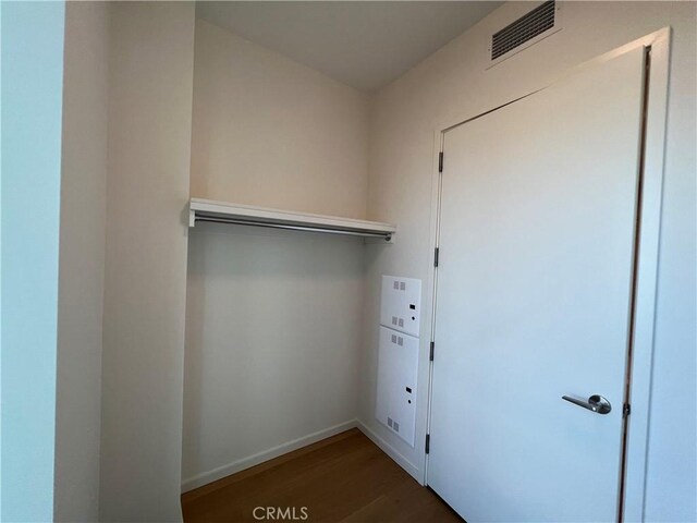 laundry room featuring baseboards, laundry area, visible vents, and wood finished floors