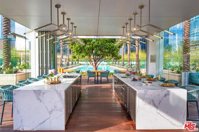 view of patio with a sink, a swimming pool, a ceiling fan, and outdoor dining space