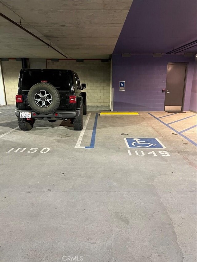 view of vehicle parking featuring a parking garage