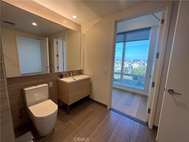 bathroom featuring vanity, toilet, recessed lighting, baseboards, and visible vents