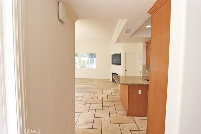 hall featuring stone finish floor, visible vents, and recessed lighting