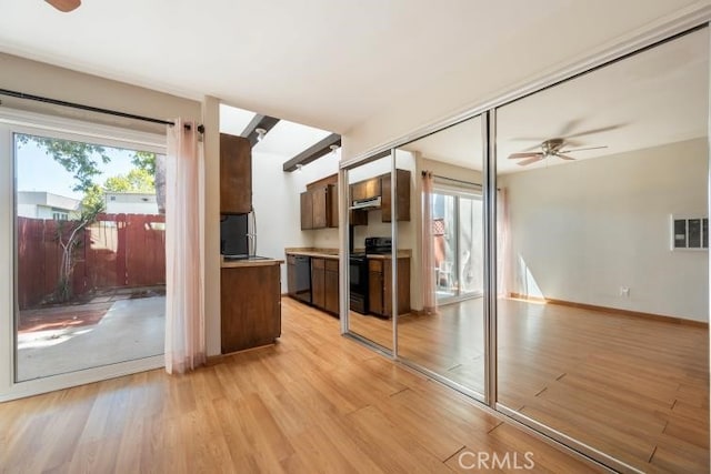 kitchen with plenty of natural light, a ceiling fan, light wood-style flooring, and black appliances