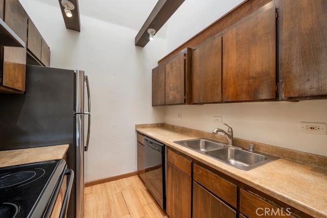 kitchen featuring light wood-type flooring, light countertops, wall chimney exhaust hood, a sink, and dishwasher