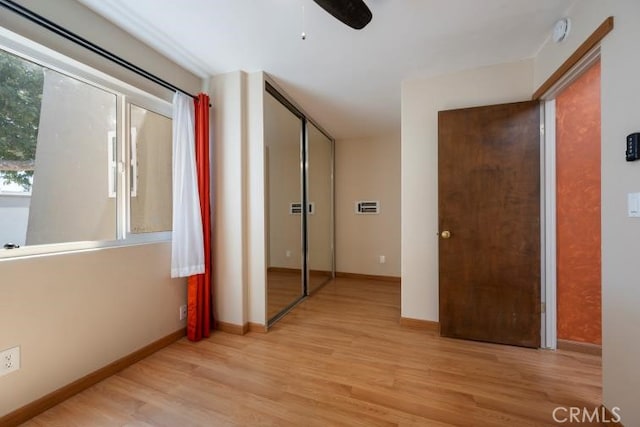 interior space with baseboards and light wood finished floors