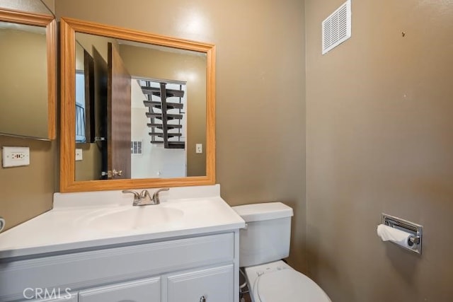 bathroom with vanity, visible vents, and toilet