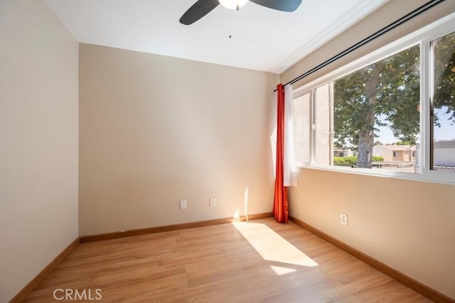 spare room featuring baseboards, a ceiling fan, and wood finished floors