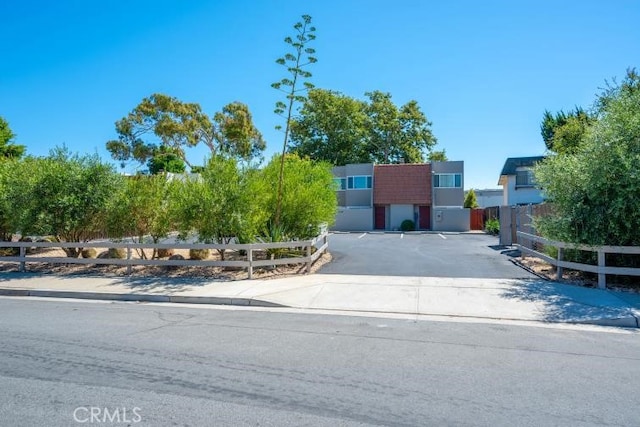 view of front facade with fence and uncovered parking