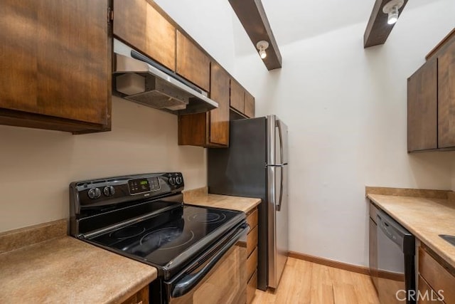 kitchen with appliances with stainless steel finishes, light countertops, baseboards, light wood finished floors, and under cabinet range hood